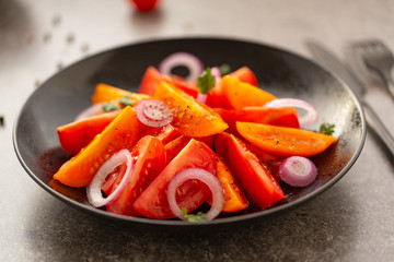 Fresh tomato salad with onion, parsley, spices and olive oil