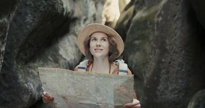 girl tourist with map in hand walking on a rocks path. young woman traveler