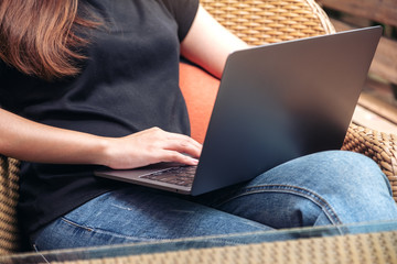 Naklejka premium Closeup image of woman using and typing on laptop keyboard while sitting with feeling relaxed