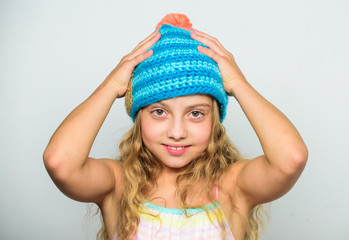 Fall winter season accessory. Knitted hat with pompon. Girl long hair happy face white background. Difference between knitting and crochet. Kid wear warm soft knitted blue hat. Free knitting patterns