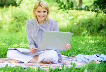 Woman with laptop sit on rug grass meadow. Online freelance career concept. Guide starting...