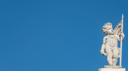 Fototapeta na wymiar Beautiful angel as defender at the roof top in front of blue sky in Vienna, Austria, details, closeup
