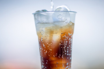 A glass of water, a close-up view of cold ice, a glass of soft drinks (soft drinks, alcohol, nectar) placed on a wooden table, managed by the client or eaten to refresh the body.