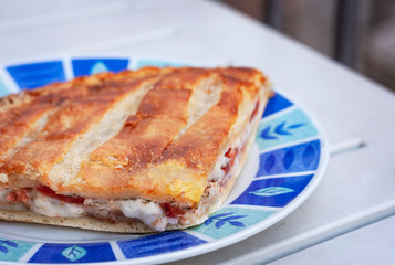Fried calzone pizza with ham, mozzarella, tomatoes from bakery shop of Catania, Sicily, Italy