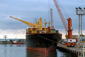 Large container ship moored for loading at the port