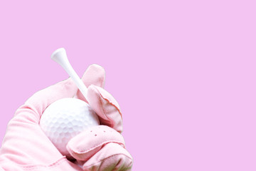 Hand of lady golfer is holding tee and golf ball 