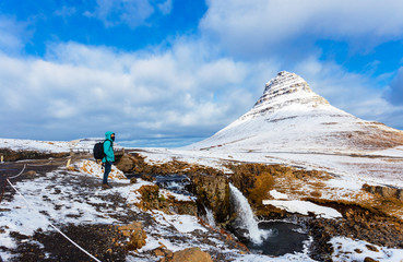 Fototapeta premium Traveller standing and looking at Kirkjufell mountain in winter season , Iceland