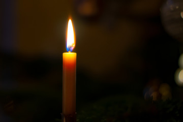 brennende Christbaumkerze links