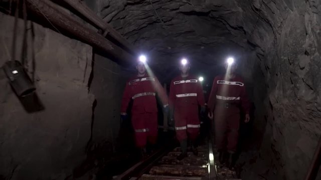 Workers in mine perforating the rock using a pneumatic drill