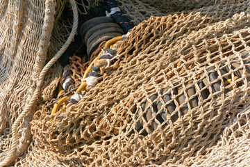 Structure of multiple brown fishing nets on a fishing ship drying in the sun    