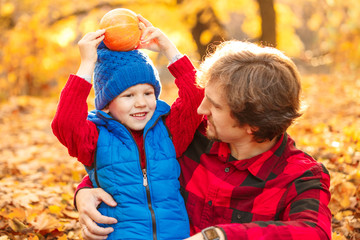 Father walks with his son in the autumn park. A child and a man in the forest are having fun on a walk. Family spends time in nature