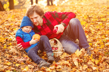 Father walks with his son in the autumn park. A child and a man in the forest are having fun on a walk. Family spends time in nature