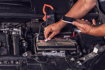 Car service worker diagnoses car breakdown.