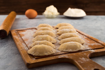 Dumplings of dough sprinkled with flour on the kitchen cutting Board.