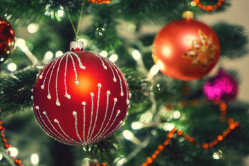 Christmas red ball hanging on a pine. Closeup shot