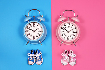 Two alarm clocks on blue pink background, boy or girl concept