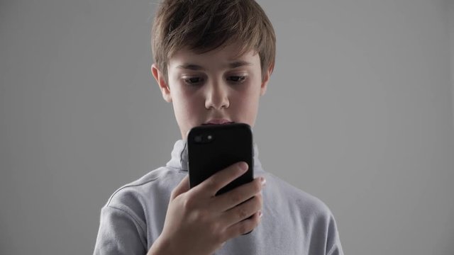 Portrait of Young 11 - 12 year old Boy using Smartphone on white background
