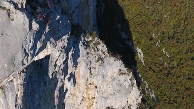 Aerial shot of a man base jumping in slow motion from a cliff in choranche vercors massif France. 