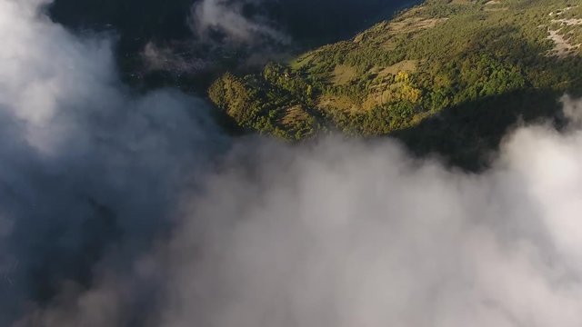 Flying over clouds discovering the beautiful Vercors massif in France. From vertical to horizontal view.
