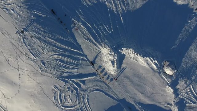 Flying over sled dog ride in a snowy landscape, la plagne france. Sunny day vertical view