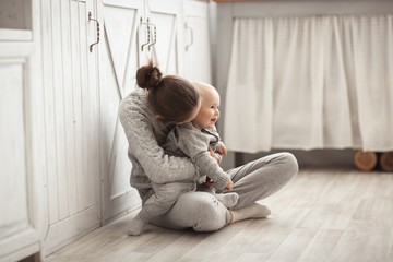 Mom gently and firmly hugs baby 10 months, cozy