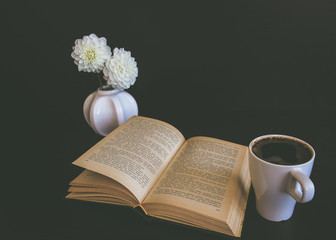 Cup of tea or coffee in the autumn at home. Decorated with dahlia, reading a book