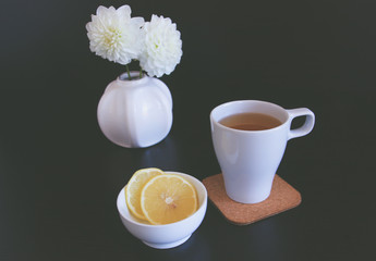 Cup of tea or coffee in the autumn at home. Decorated with dahlia, reading a book