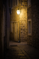 Obraz premium Old street at night illuminated by vintage streetlight.