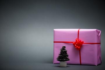 Paper Christmas tree and gifts on gray background.