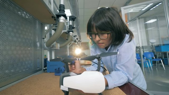 A child fixing a drone in a laboratory, close up.