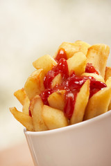 WHITE BOWL OF FRIED CHIPS AND TOMATO KETCHUP