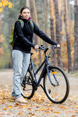 Happy young woman with bicycle