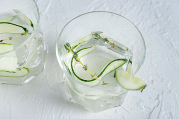 Glasses of fresh cucumber water on white table