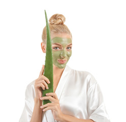 Beautiful young woman with facial mask containing aloe vera extract, on white background