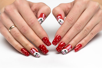 New Year's red manicure with hares and white dots, snow on long square nails on a white background close-up © dina_shuba