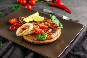 Plate with delicious roasted sausage and vegetables on table