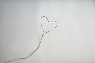 Heart made of wire on grey background