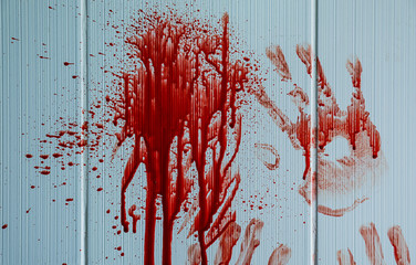 Blood stains with palm prints on light wall