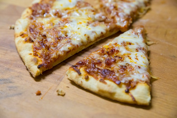 Italian traditional cuisine, pizza, food background. Fresh baked pizza with prosciutto and arugula on wooden table, copy space. Restaurant menu photo.
