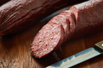 Sujuk (sucuk), a dry spicy sausage on wooden background