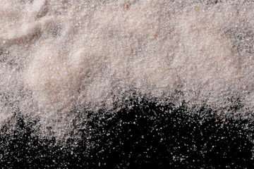 Himalayan salt pile isolated on black background, top view