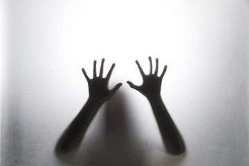 Shadow hands of the woman behind the white curtain