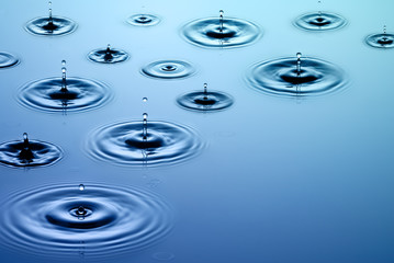 Falling rain - raindrops fall on smooth surface of water