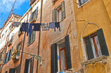 Fototapeta na wymiar Venice colorful corners with old buildings and picturesque building facade with windows and clothes hanging between houses out to dry Venice, Italy