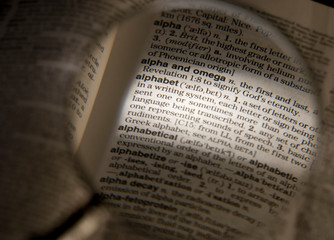 Fototapeta premium MAGNIFYING GLASS ON DICTIONARY PAGE SHOWING DEFINITION OF THE WORD ALPHABET