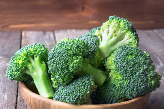 Healthy fresh sliced broccoli on wooden board. Green vegetables. 