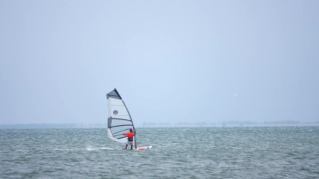 Windsurfer silhouette over sea
