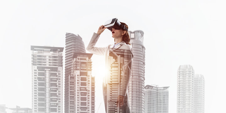 Woman in mask against sunrise above city trying virtual reality