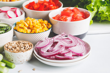 Assortment ingredients for healthy vegetarian salad in different portion bowls on a table. The concept of fitness and vegan food.