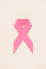 top view of breast cancer awareness pink ribbon on beige 